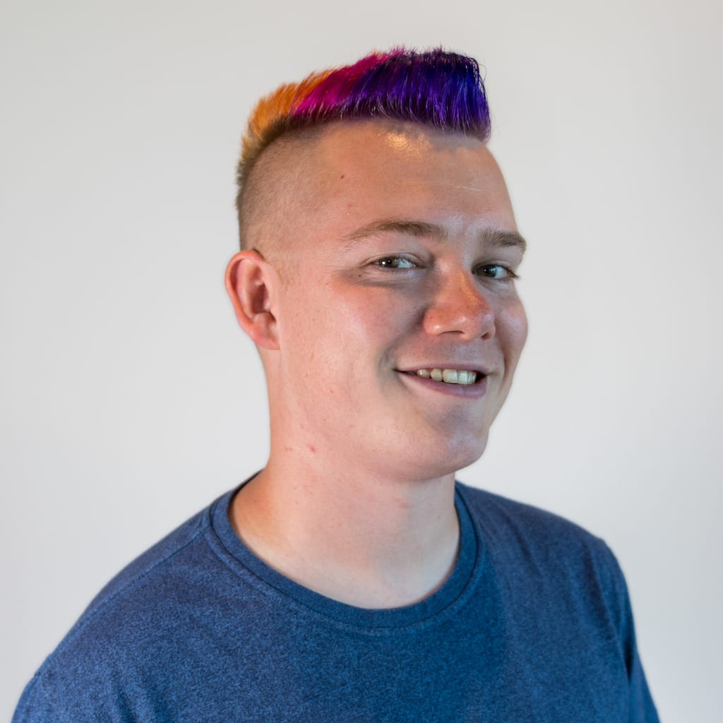 Profile photo of Jack Skinner with a purple-pink-orange gradient mohawk and a blue tee shirt.